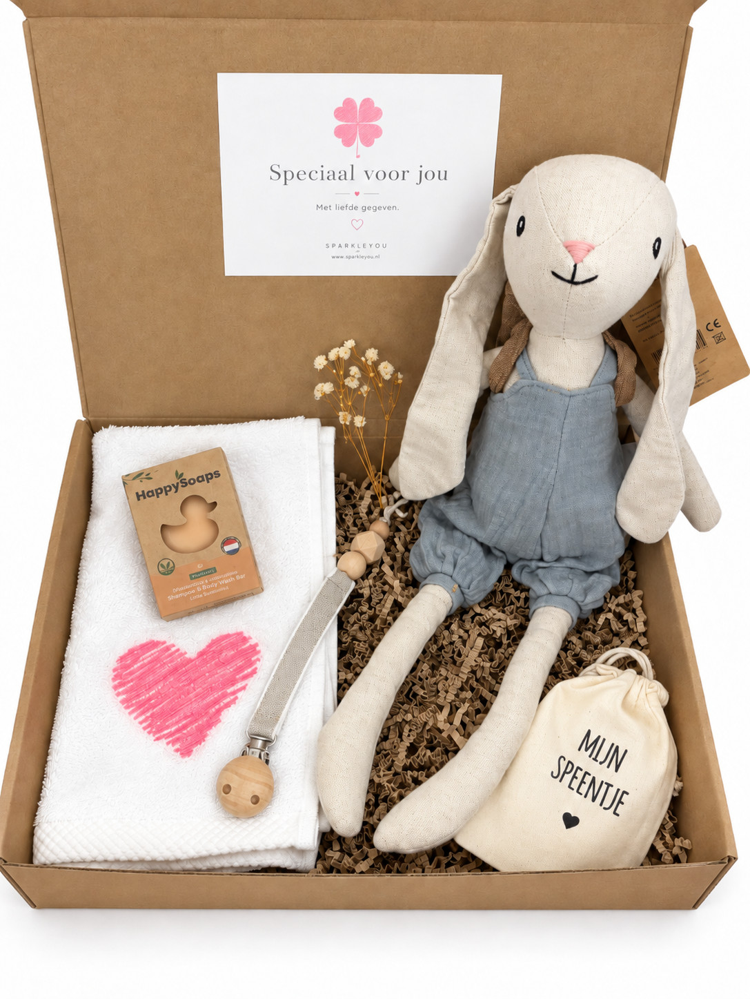 Open cadeauverpakking met knuffelkonijn Hugo, wit doekje met roze hart, babybar, speenkoord en speenzakje